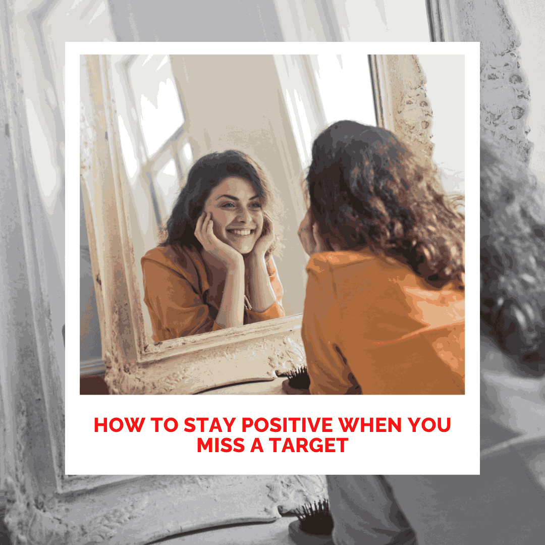 Woman smiling at her reflection in mirror, promoting positivity and self-love.