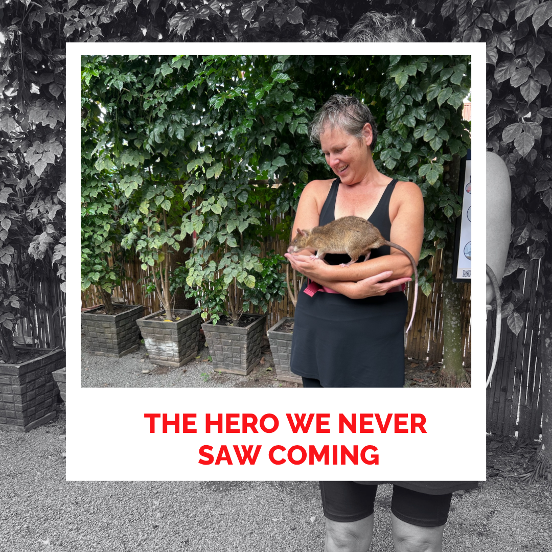 Laura Foster holding a rat outdoors with greenery in the background.