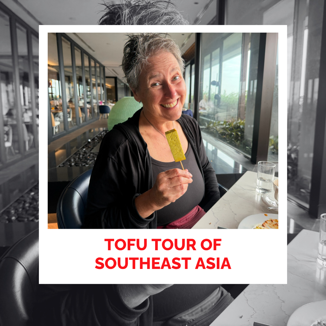 Smiling woman enjoying tofu at Southeast Asia food tour.